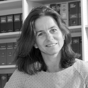 Porträt von Melanie Scheibel vor einem Regal mit Fachliteratur in Schwarzweiß